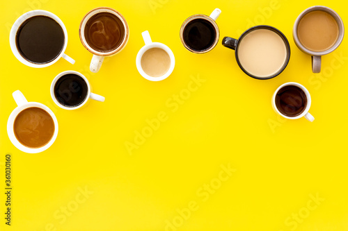 Lots of coffee on yellow desk top-down space for text photo