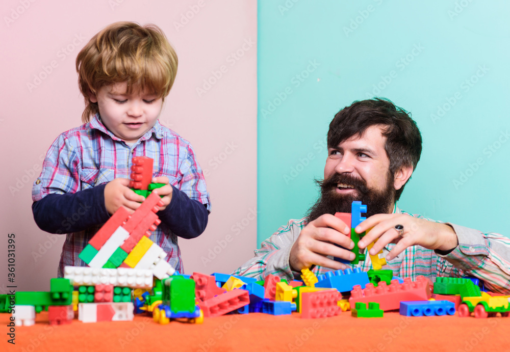 Father son game. Father and son create colorful constructions with bricks. Bearded father and boy play together. Dad and kid build of plastic blocks. Useful toy. Child care development and upbringing Father son game. Father and son create colorful constructions with bricks. Bearded father and boy play together. Dad and kid build of plastic blocks. Useful toy. Child care development and upbringing