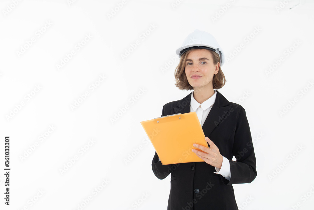 Portrait of a woman in hard hat and suit looking at camera while standing and holding clipboard with documents isolated over white background. Portrait of a woman in hard hat and suit looking at camera while standing and holding clipboard with documents isolated over white background.