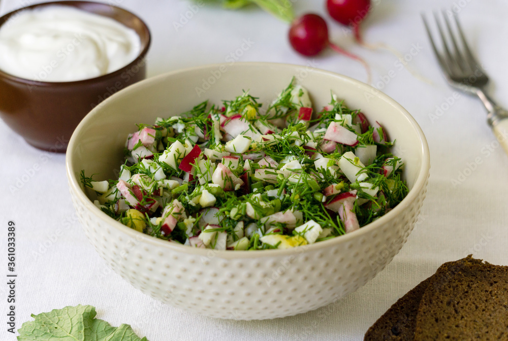 Salad with radish, eggs and dill on a white fabric background Salad with radish, eggs and dill on a white fabric background