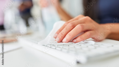 Hand einer Geschäftsfrau beim Tastatur desinfizieren