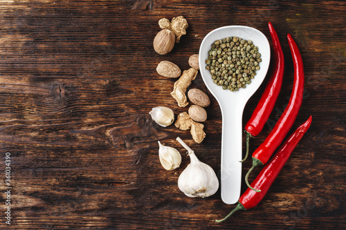 Top view of chili pepper, garlic and herbs on dark wooden surface