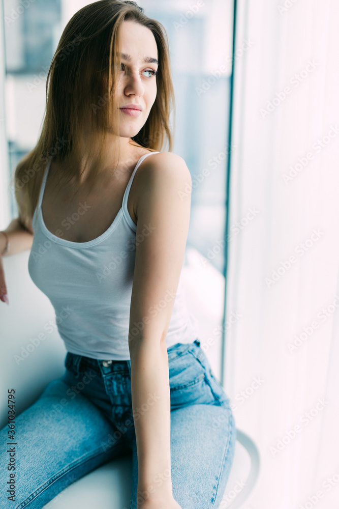Young woman resting in chair at home near window Young woman resting in chair at home near window