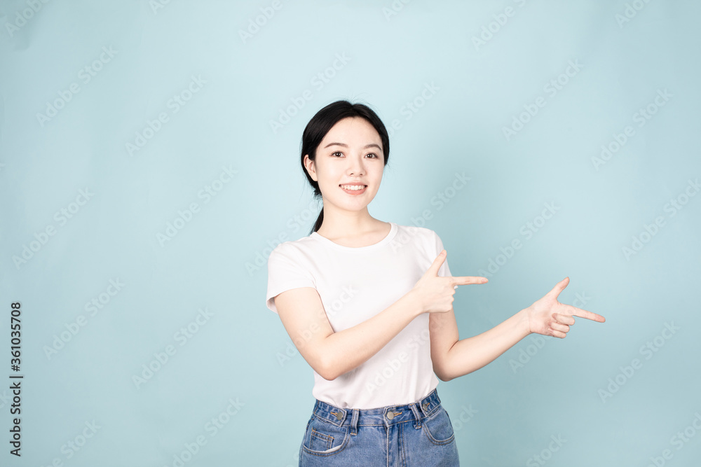 A young chinese woman in front of blue background A young chinese woman in front of blue background