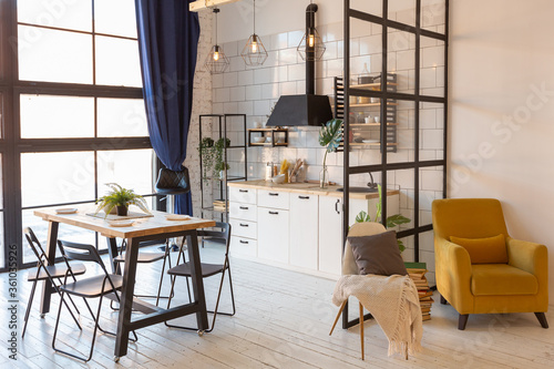 luxury modern design of a cozy small Scandinavian-style studio apartment with white walls, second floor with a library and huge high window full of day light photo