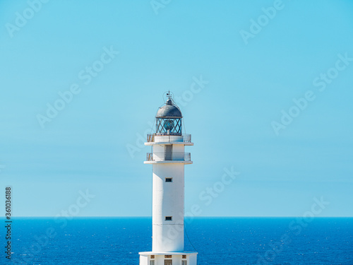 Vistas de faro blanco con playa de Formentera de fondo