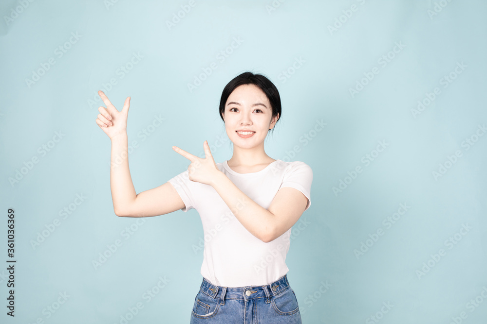 A young chinese woman in front of blue background A young chinese woman in front of blue background