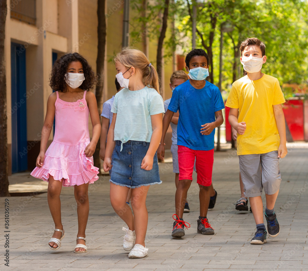 Group of positive children in masks walking together - obrazy, fototapety, plakaty 