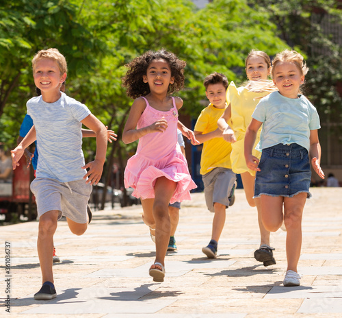 Fototapeta Naklejka Na Ścianę i Meble -  Happy children running in race and laughing outdoors