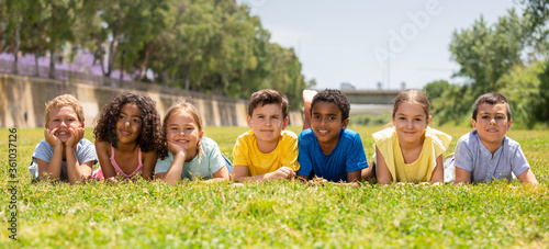 Portrait of smiling children who are posing lying in park © JackF