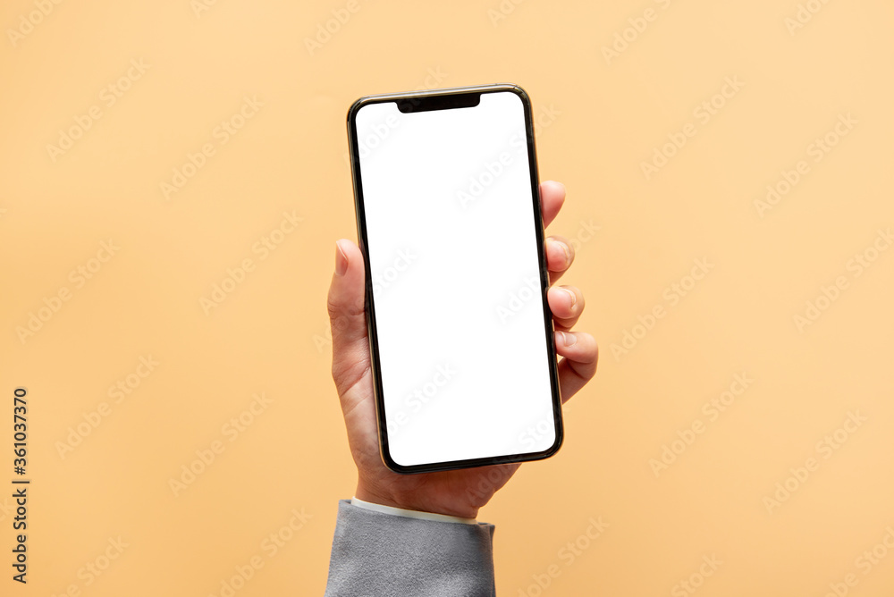 Smartphone mockup. Close up hand holding black phone white screen on yellow background. Mobile phone frameless design concept. - obrazy, fototapety, plakaty 