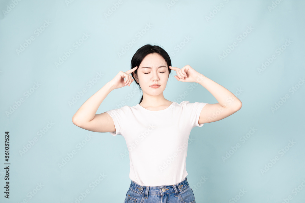 A young chinese woman in front of blue background A young chinese woman in front of blue background