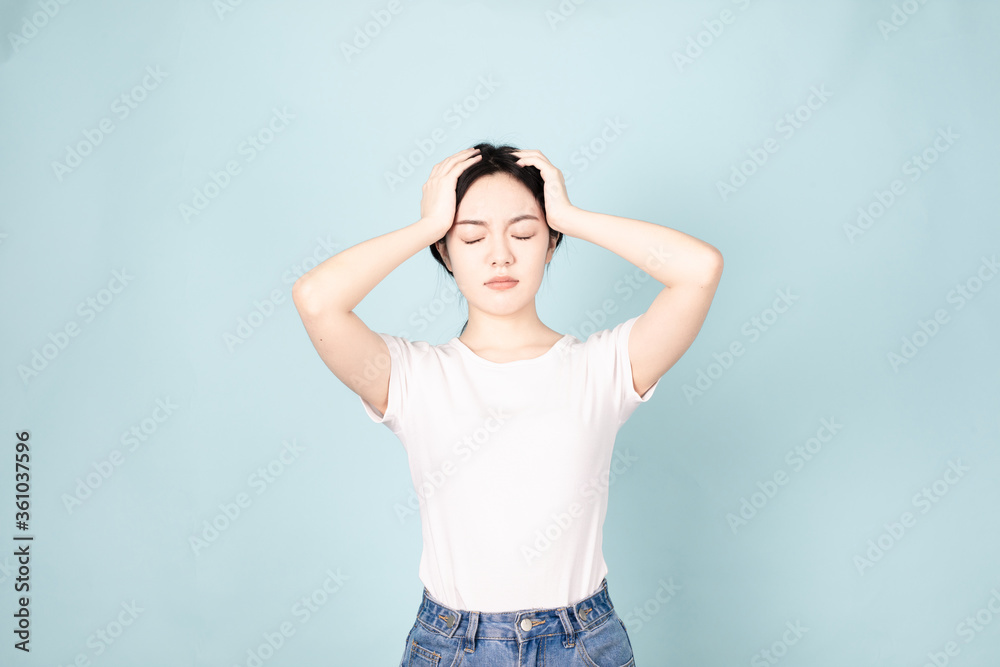 A young chinese woman in front of blue background A young chinese woman in front of blue background
