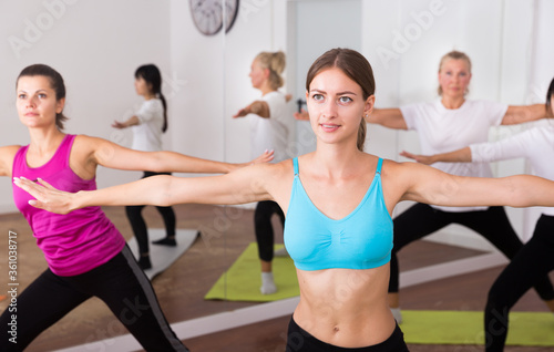 Flexible women practice yoga in a modern studio