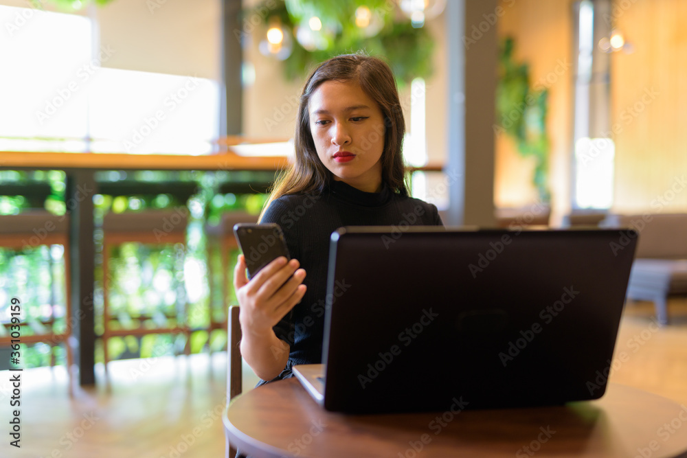 Φωτογραφία Young beautiful Asian businesswoman using phone and laptop at the coffee shop