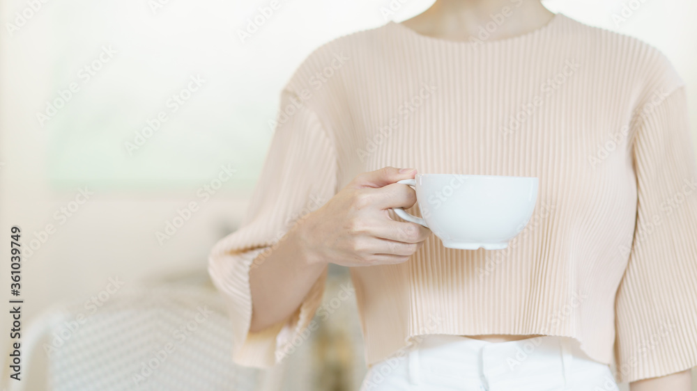 Cup of coffee. Woman hand holding tea or coffee. White cup of hot beverage in the morning.
