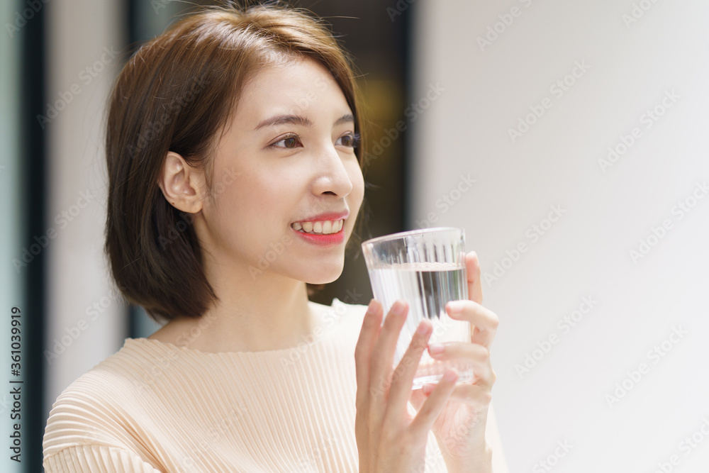 Woman holding transparent glass in her hand and drinking water. Woman holding transparent glass in her hand and drinking water.