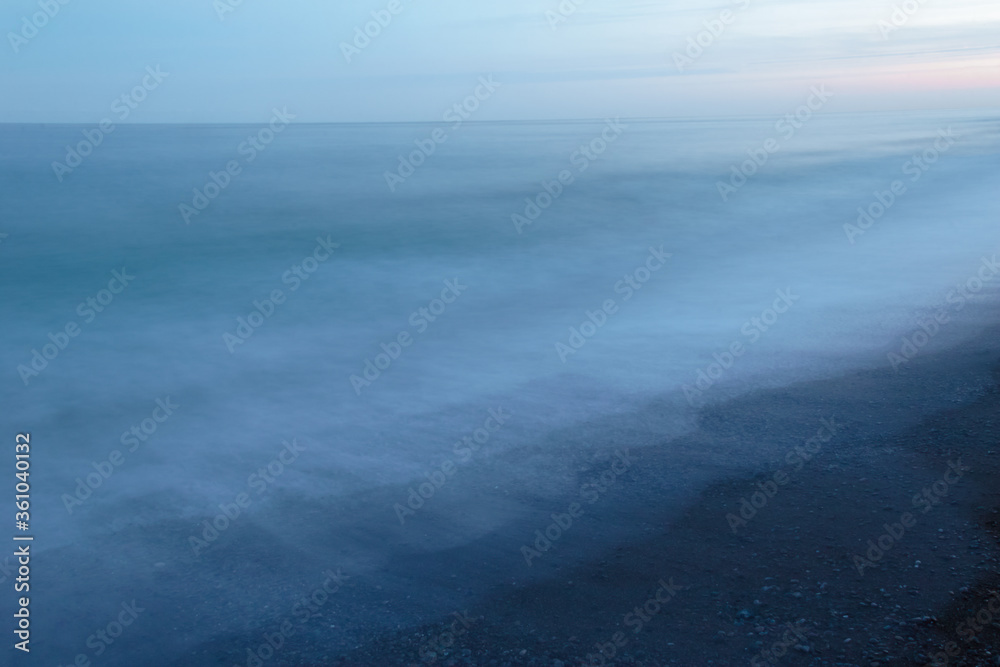 Obraz premium Sea tide at sunrise, light misty breeze