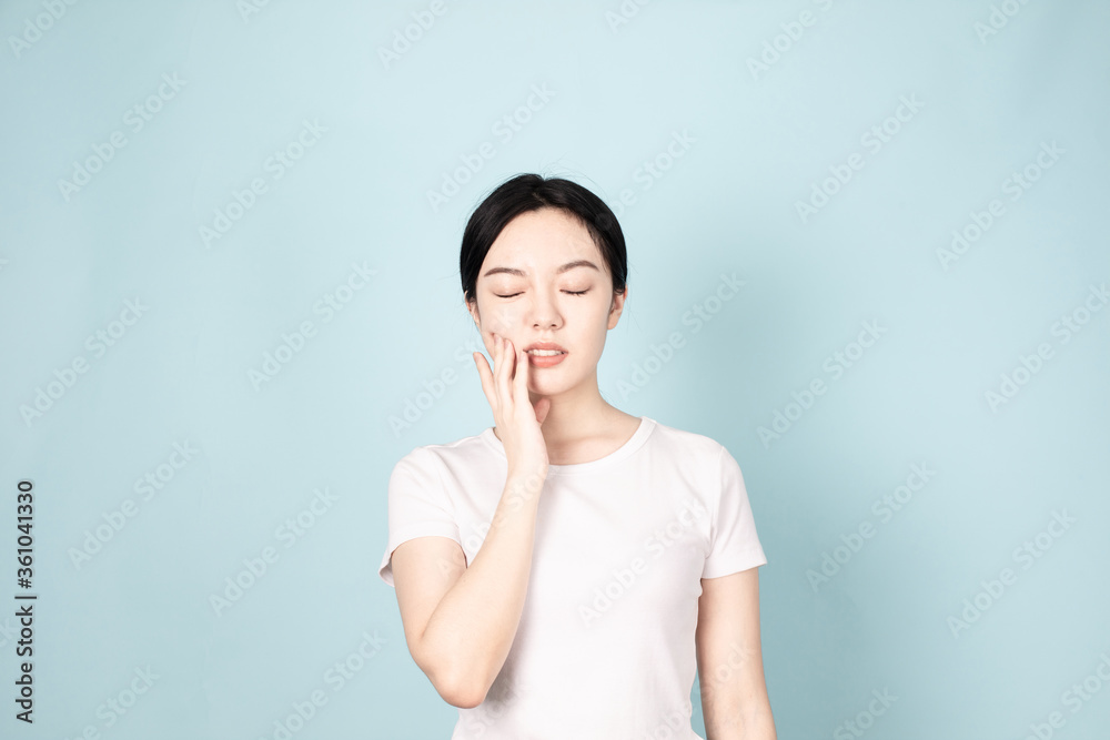 A young chinese woman in front of blue background A young chinese woman in front of blue background
