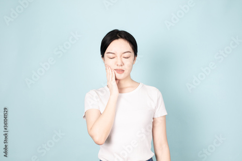 A young chinese woman in front of blue background © ACloud Man