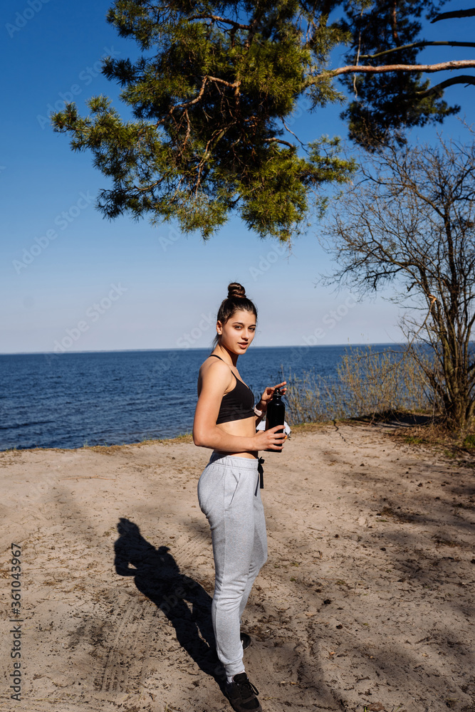 Fitness young woman walks in the park and posing for the camera