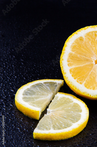 A close-up photo of chopped lemons and oranges on a black background.