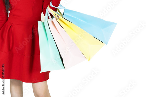 young beautiful woman in red dress carrying color pastel shopping bag isolated banner white background with copy space