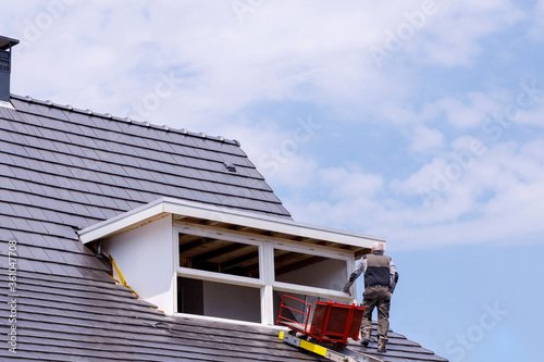 Roofer Working On A New Dormer Construction on the Roof.