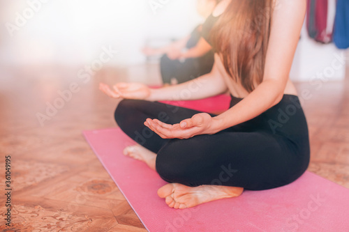 Beautiful young girls do yoga on rugs, relax, care about health