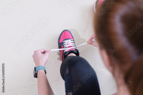 The woman tie her shoes.