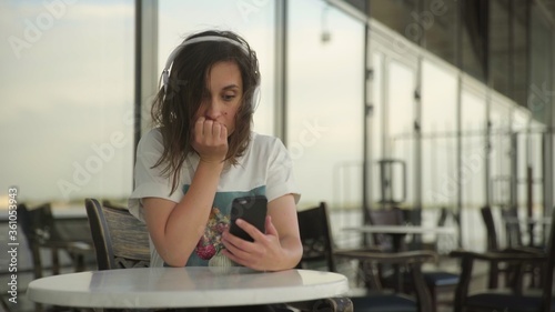 Young woman in headphones looking at the smartphone