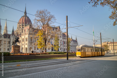 Square before Hungarian paliament building with moving tram in Budapest.