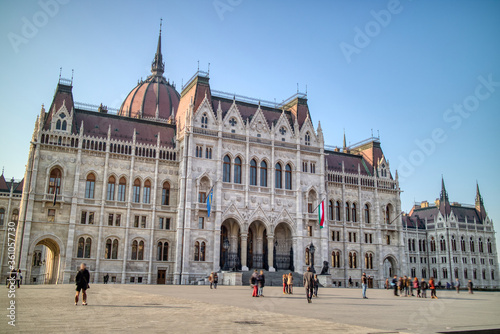 The Hungarian paliament building with walking people around square, Budapest.