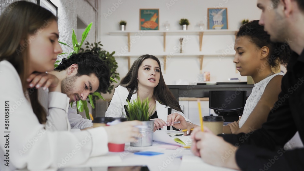 Female team leader at office meeting. Young multiethnic business people brainstorm in trendy coworking Female team leader at office meeting. Young multiethnic business people brainstorm in trendy coworking