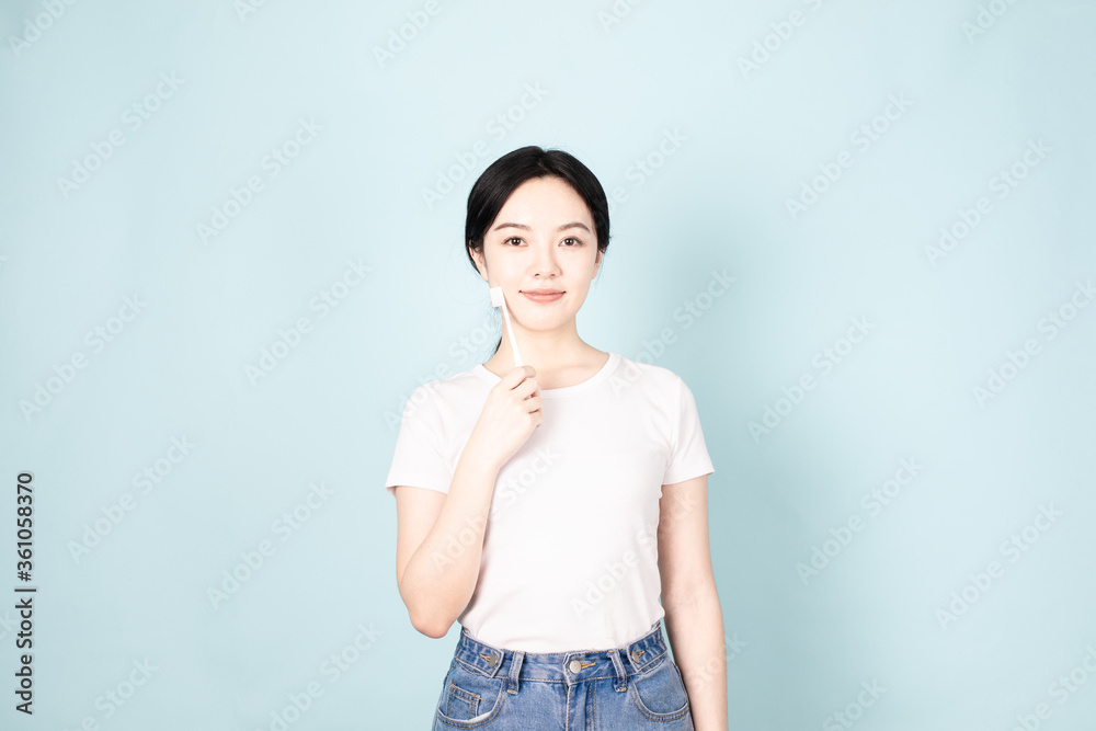 A Young Chinese Woman In Front of Blue Background