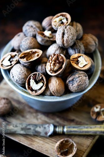 Walnuts in a bowl on a dark background. Unpeeled walnuts. Inshell walnuts.