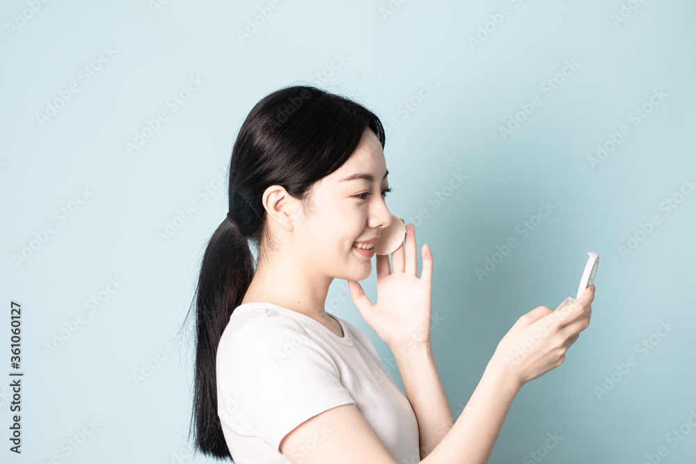 A Young Chinese woman in front of a blue background A Young Chinese woman in front of a blue background