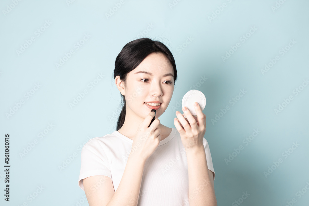A Young Chinese woman in front of a blue background A Young Chinese woman in front of a blue background