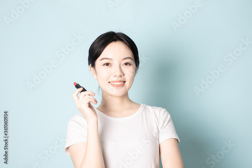 A Young Chinese woman in front of a blue background © ACloud Man