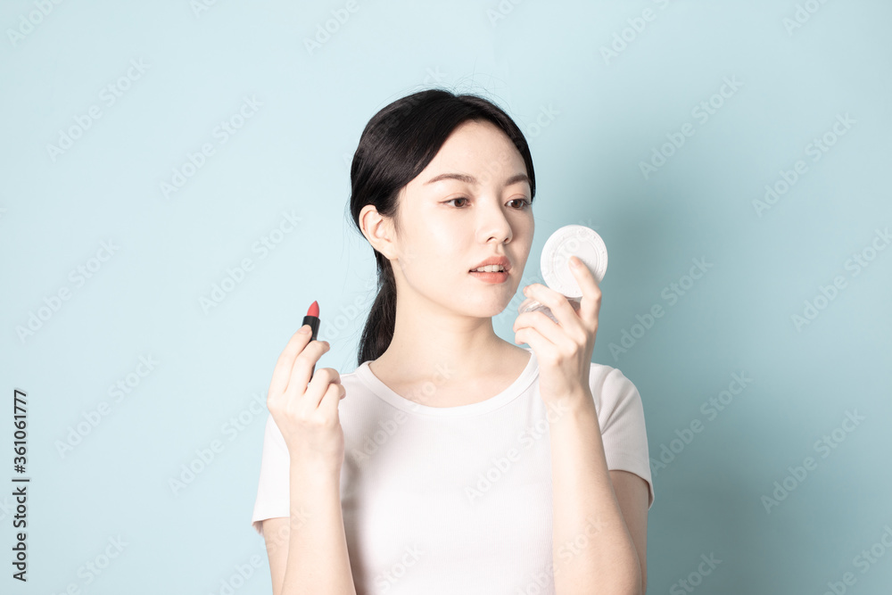 A Young Chinese woman in front of a blue background A Young Chinese woman in front of a blue background