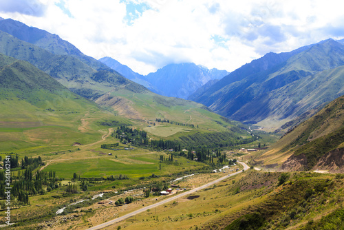 View of the gorge in the mountains. The village and the road. Summer landscape. Kyrgyzstan Issyk-ata gorge.