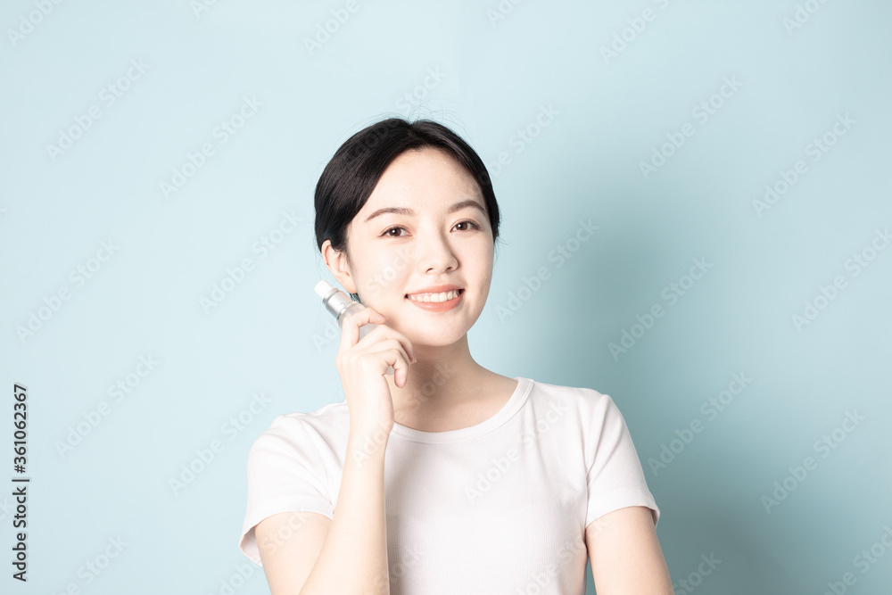 A Young Chinese woman in front of a blue background A Young Chinese woman in front of a blue background