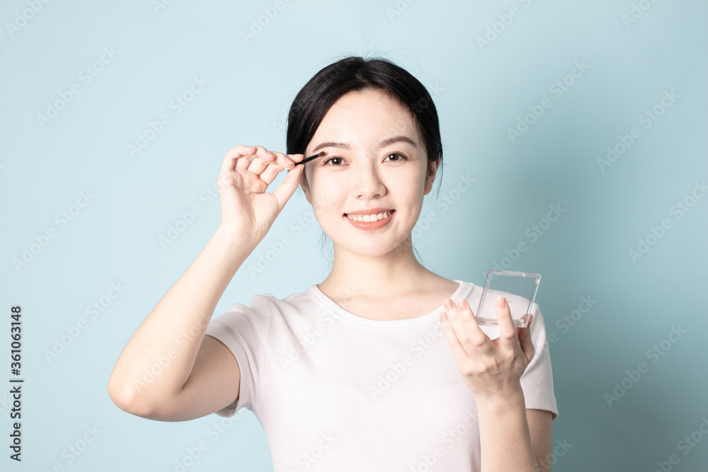 A Young Chinese woman in front of a blue background A Young Chinese woman in front of a blue background