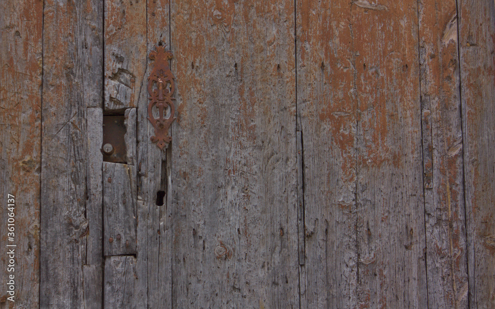 Fondo de madera de una puerta antigua con una aldaba de la misma época 
