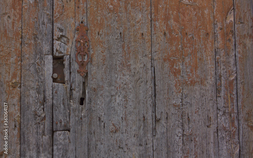Fondo de madera de una puerta antigua con una aldaba de la misma época 