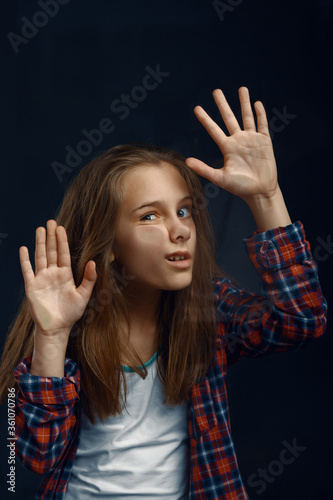 Little girl makes face leaning against the glass