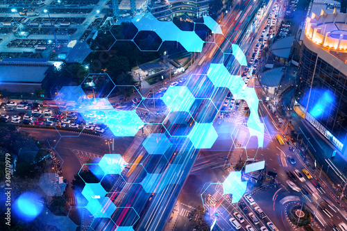 Abstract technology icons hologram on aerial top view of road, busy urban traffic highway at night. Junction network of transportation infrastructure. The concept of hi-tech in logistics.