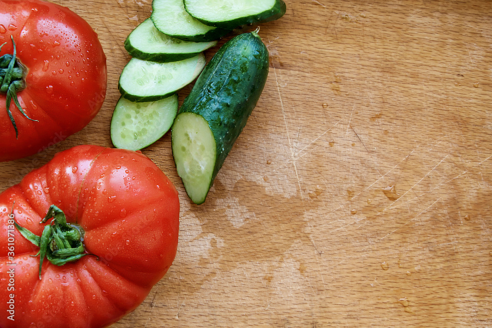 Tomatoes and cucumber on a wooden cutting board. Scratch Tomatoes and cucumber on a wooden cutting board. Scratch
