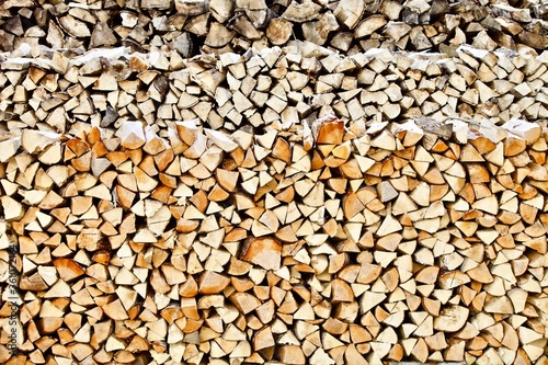 Stacked firewood close-up. Firewood storage close up. Stocks of wooden logs close-up. Chopping wood. Logging in the village. Rustic lifestyle. Woodpile with firewood full frame image. Wooden texture.