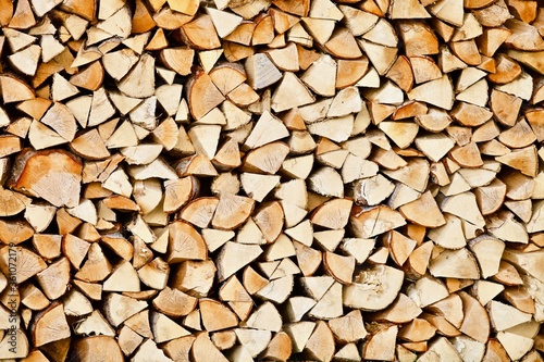 Stacked firewood close-up. Firewood storage close up. Stocks of wooden logs close-up. Chopping wood. Logging in the village. Rustic lifestyle. Woodpile with firewood full frame image. Wooden texture.